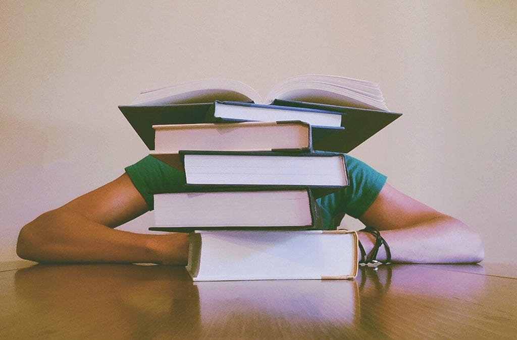 student buried behind books