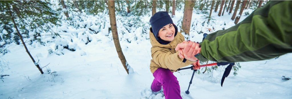 little girl getting a hand out of a snow pit