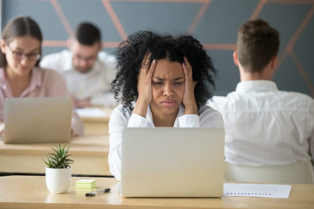 Tired black female employee stressed by lots of workload to do, desperately looking at laptop screen, upset African American worker feeling down losing money in online game or becoming bankrupt